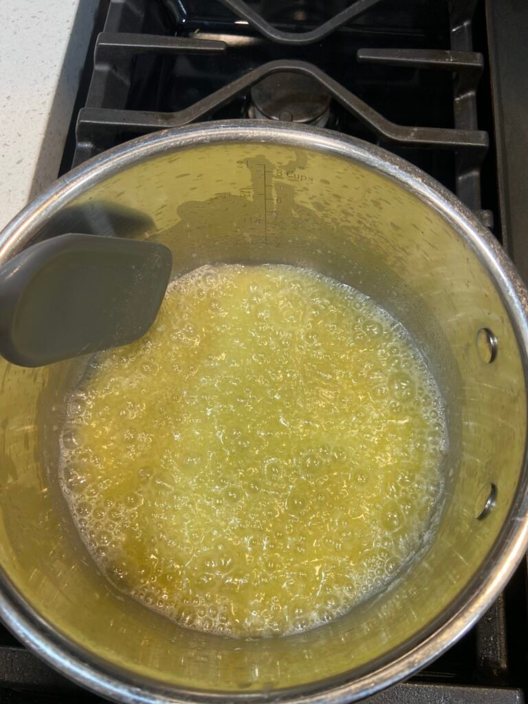 Butter melting in a saucepan at the start of the browning process.