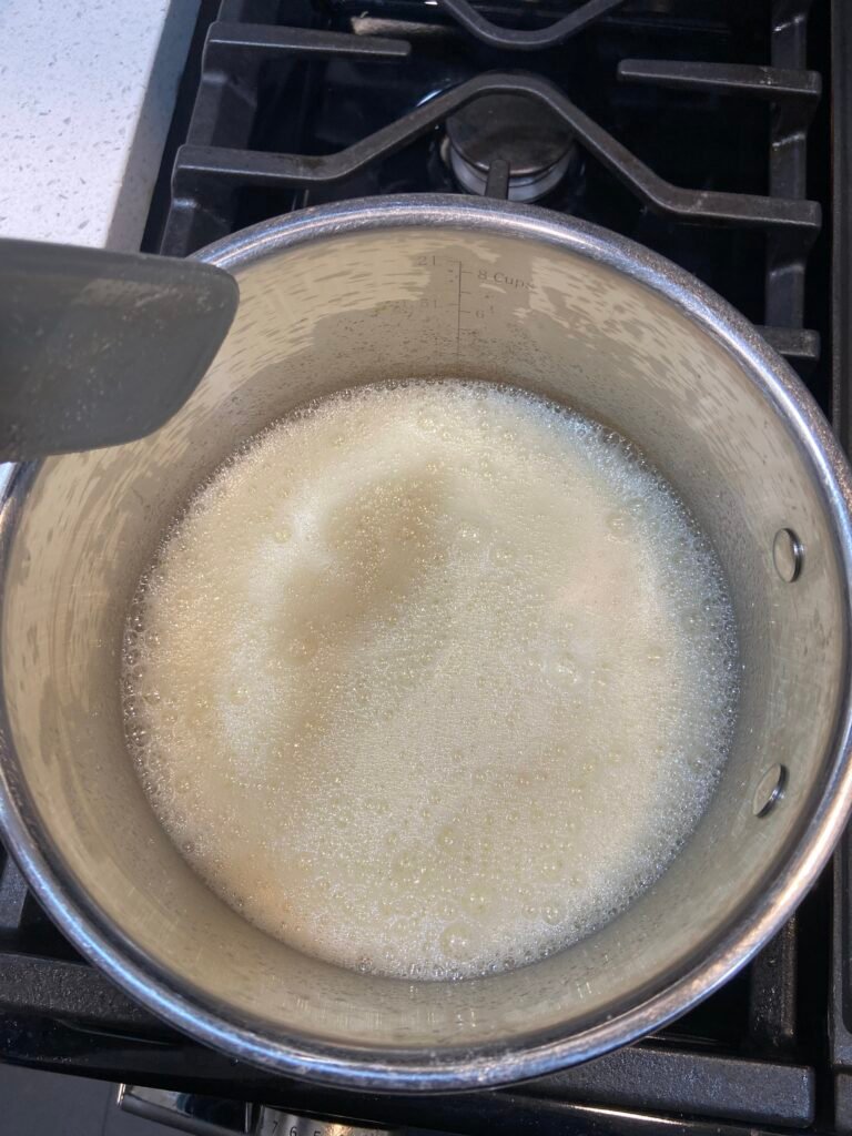 Butter foaming in a saucepan while browning on the stove.